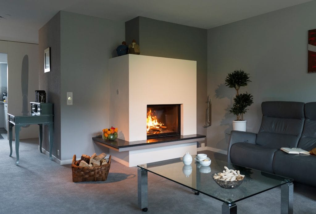 Salon contemporain avec cheminée allumée.