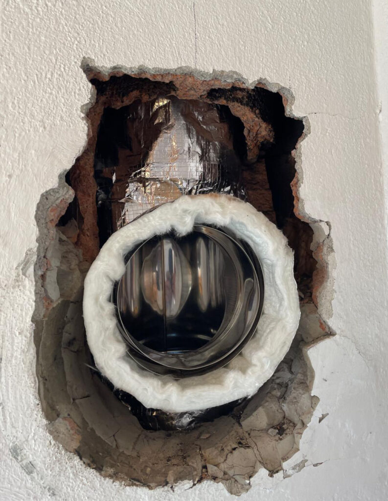 Conduit d'aération installé dans un mur.