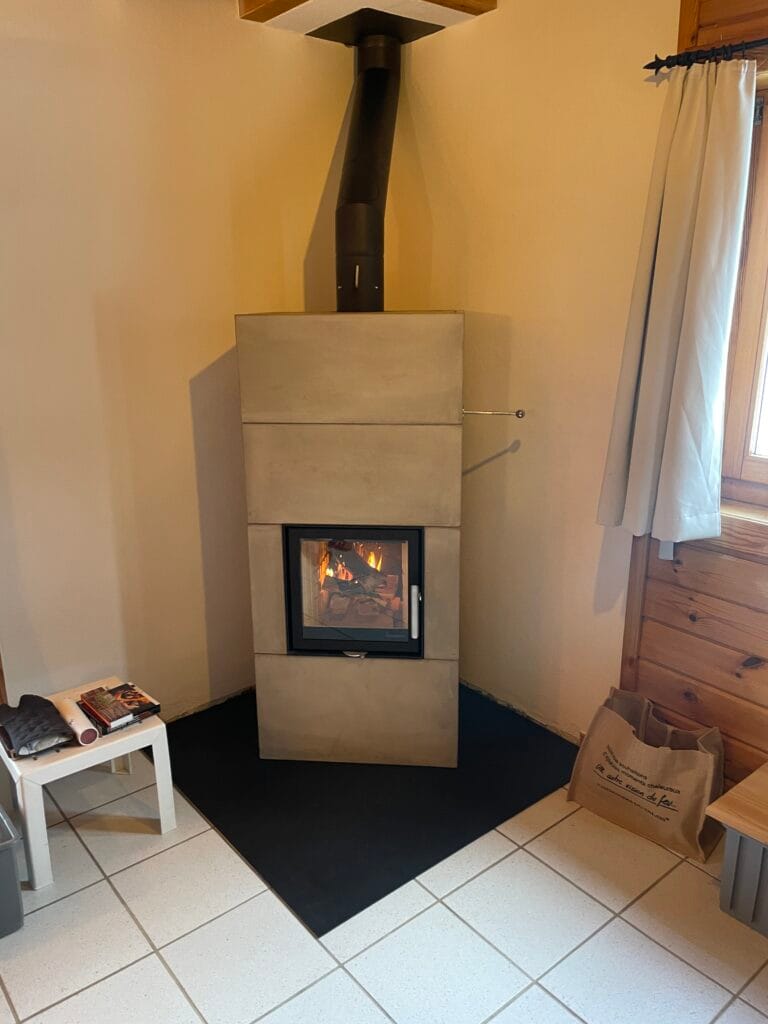 Poêle à bois moderne allumé dans un coin.