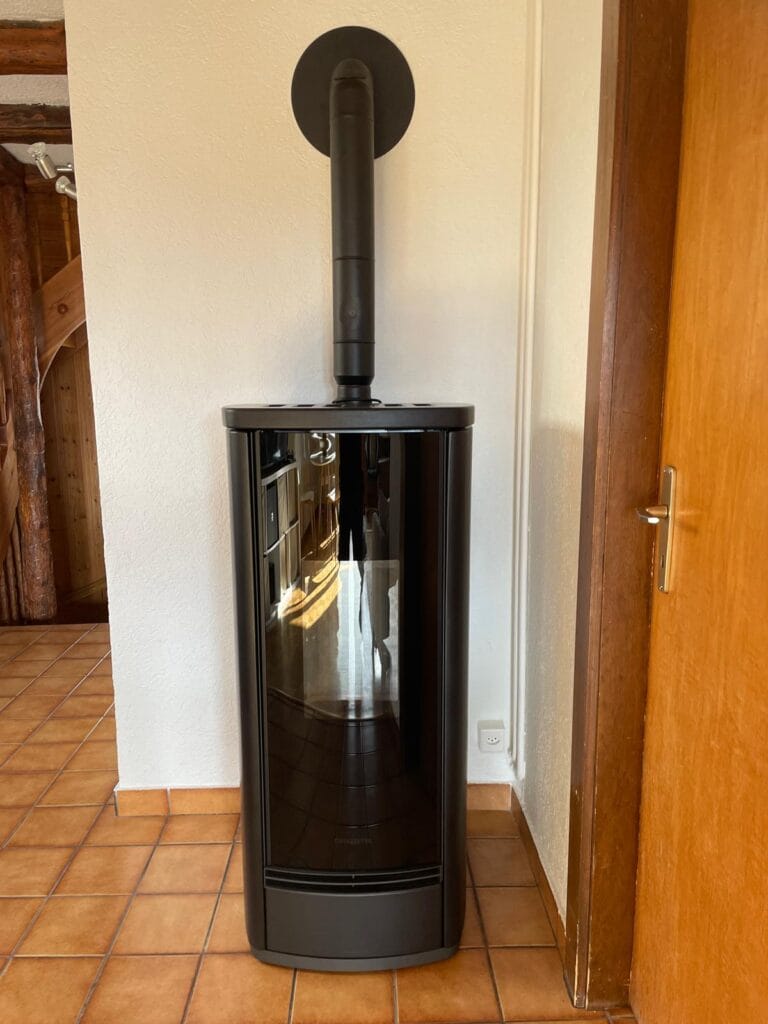 Poêle noir moderne installé sur carrelage orange.