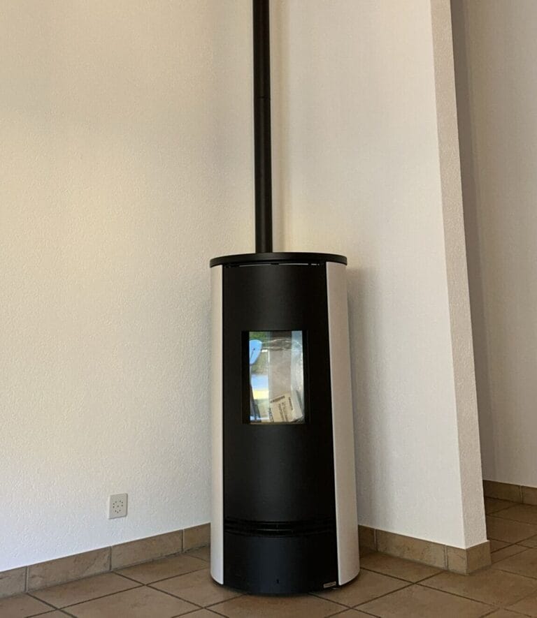 Poêle noir moderne dans un coin de pièce.