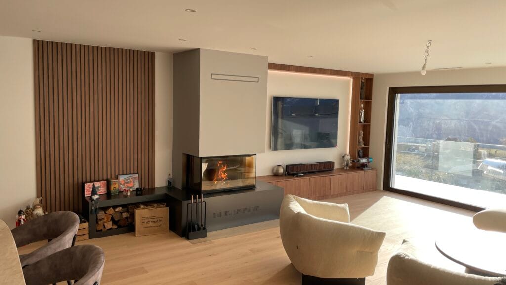 Salon moderne avec cheminée et grande fenêtre vitrée.