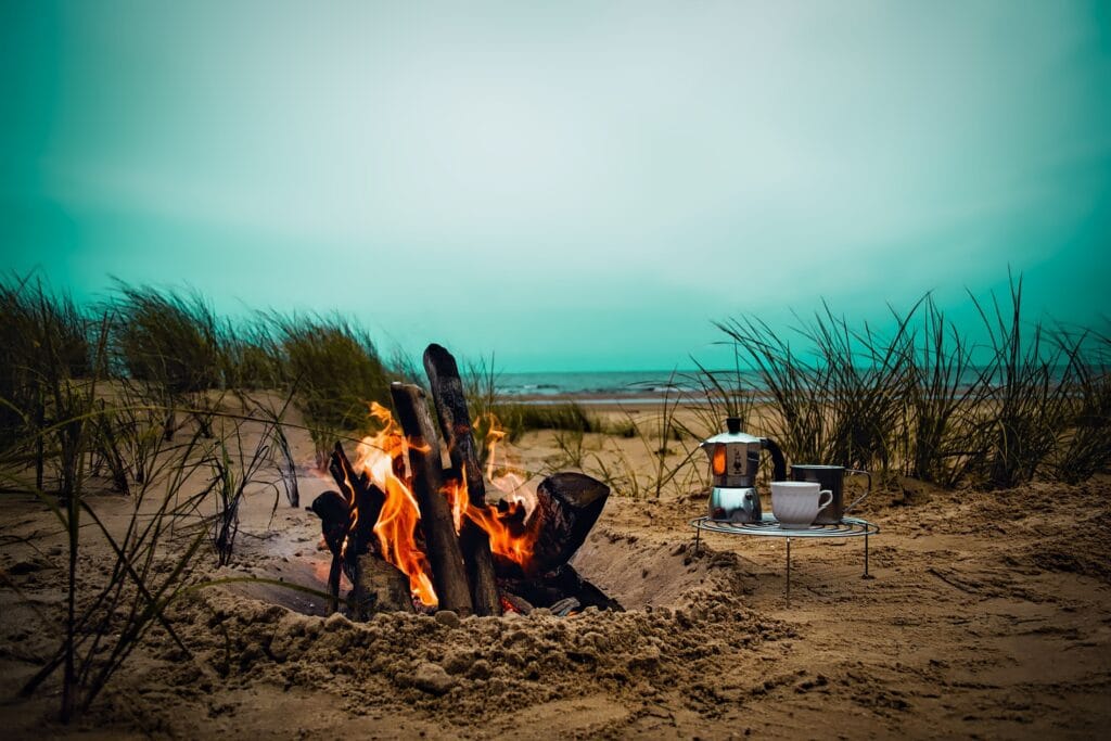 Feu de camp sur plage au coucher du jour